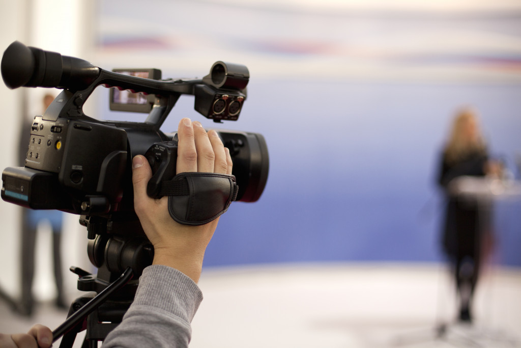 a cameraman holding his equipment while covering an event