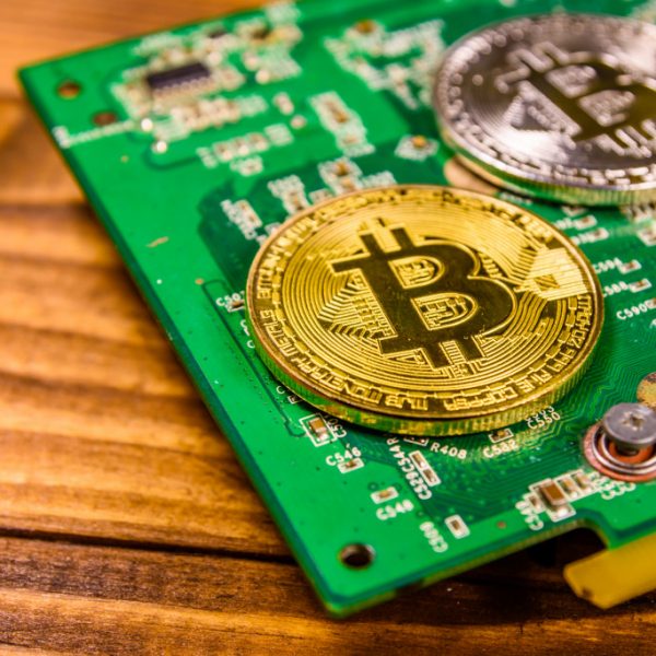 Bitcoins and circuit board on rustic wooden table
