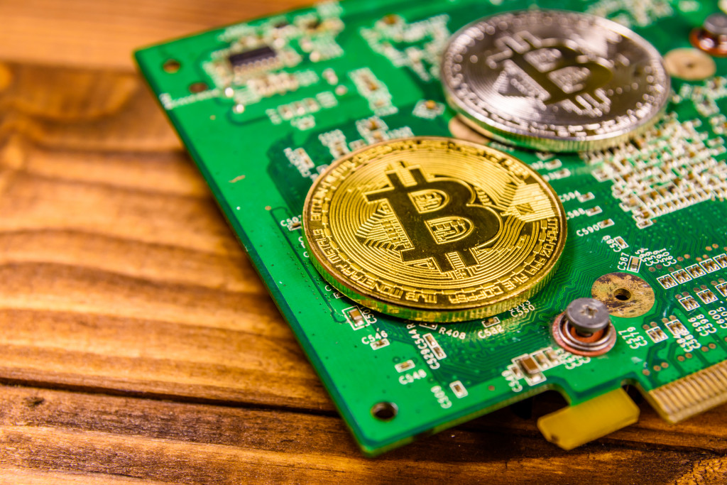 Bitcoins and circuit board on rustic wooden table