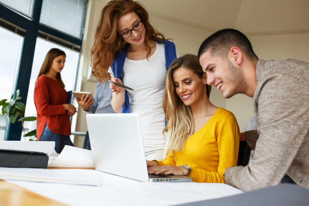 A group of young professionals working on a laptop in the office