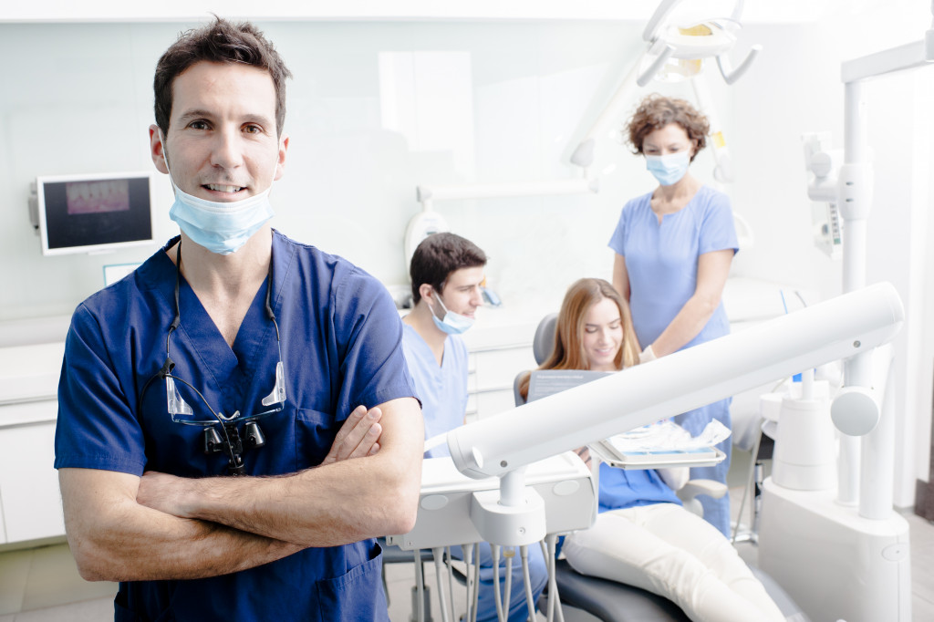 A dentist, his staff, and his patient in his clinic