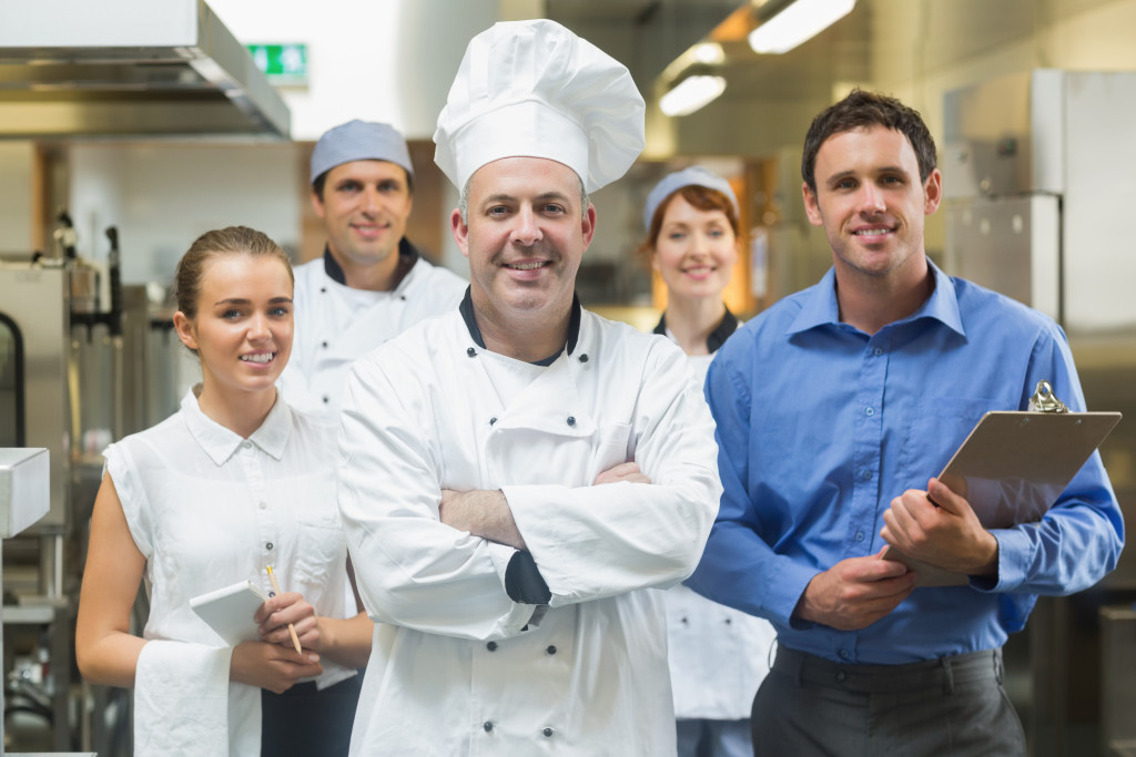 Head chef posing with the team behind him in a professional kitchen