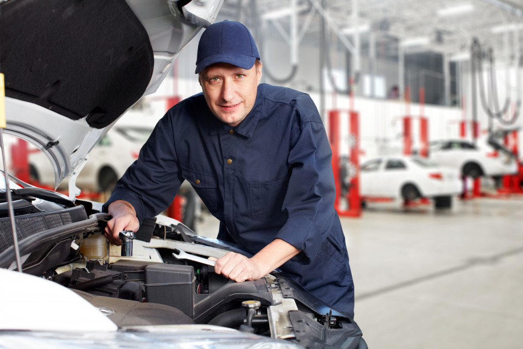 An automobile repair employee inspecting a car