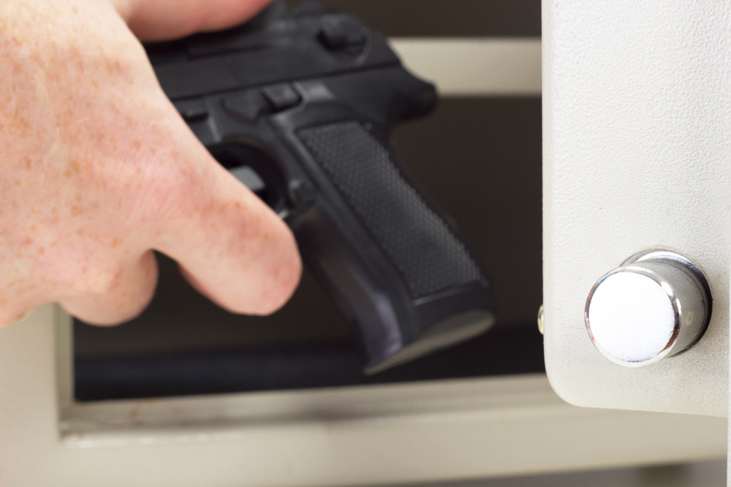 hand putting gun in safe