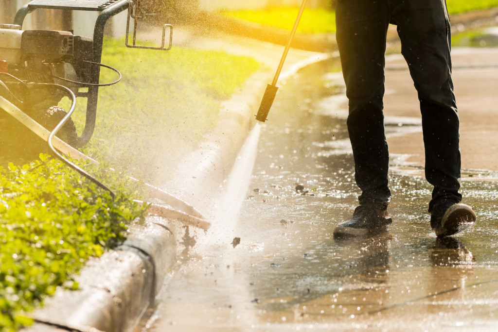 A cleaner pressure washing the pavement