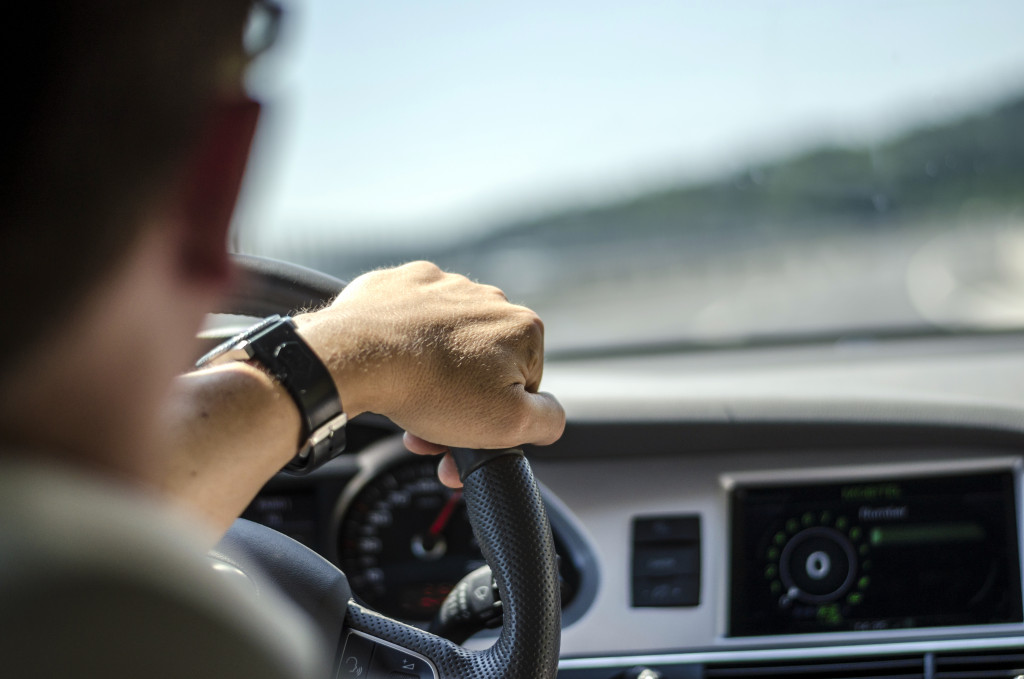 a man driving and holding the steering wheel