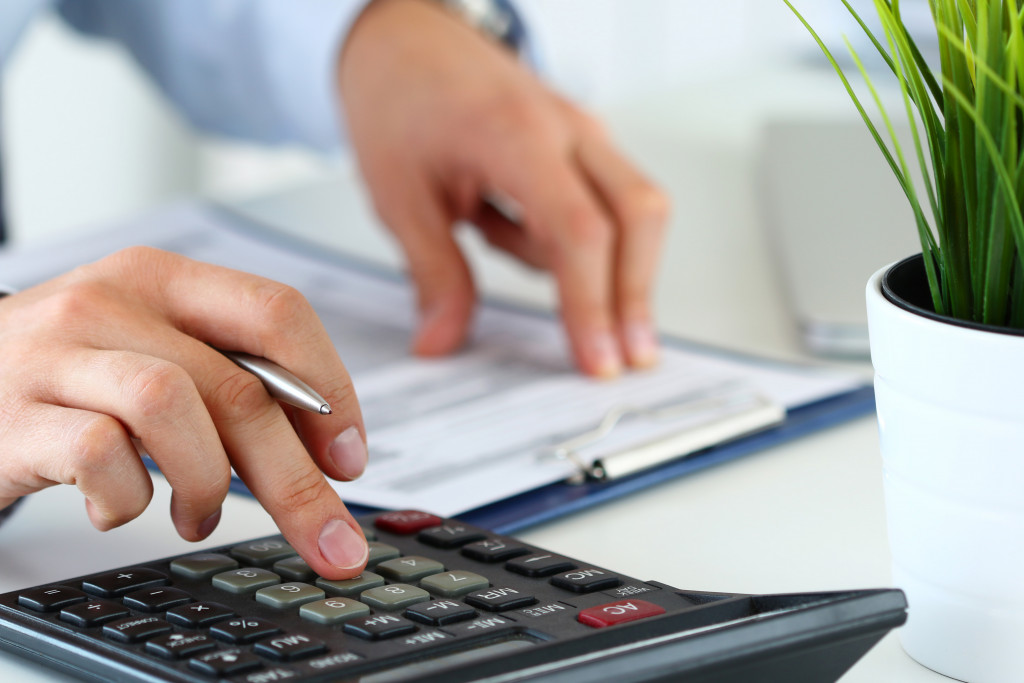 close up view of bookkeeper or financial inspector hands making report calculating or checking