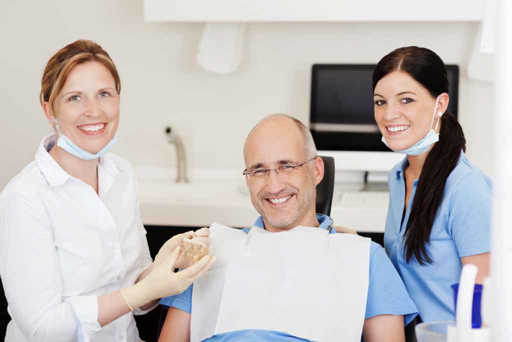 a man in a dental chair with dental professionals