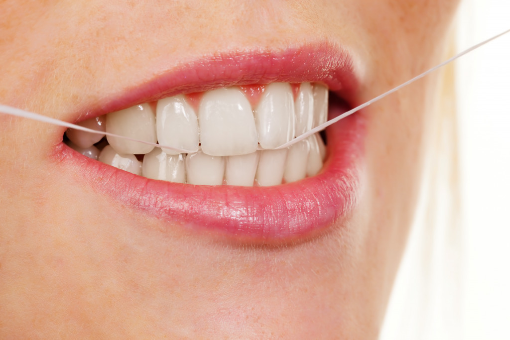 A woman flossing her teeth