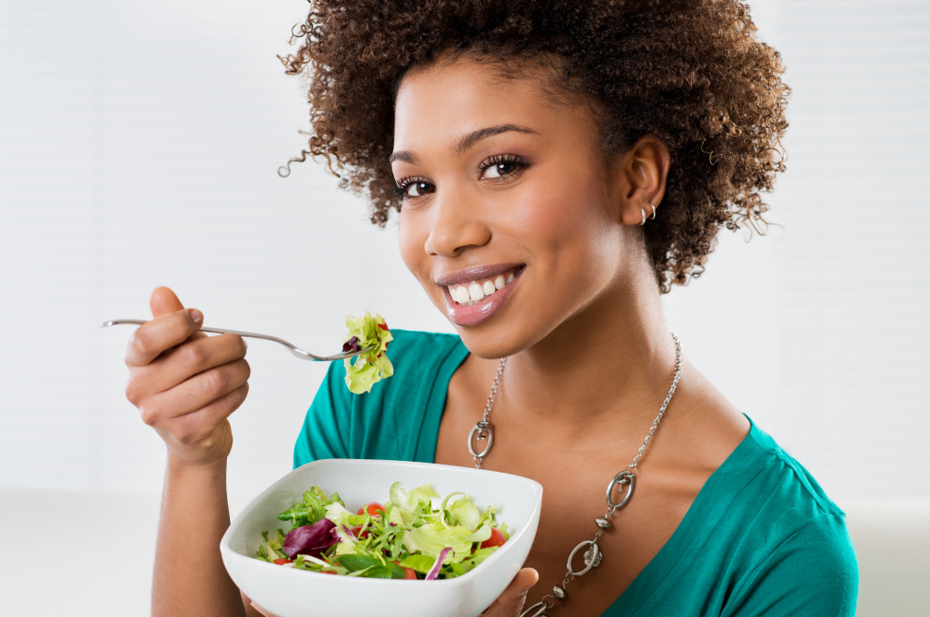 african american woman eating ceasar salad