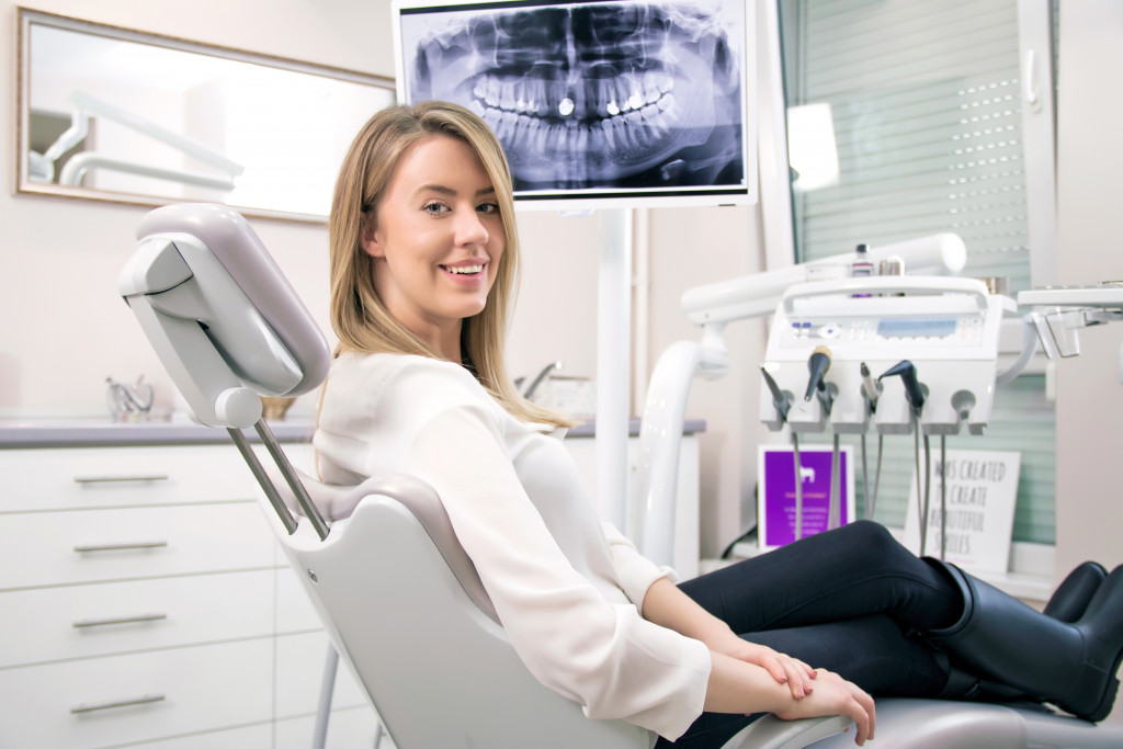 woman smiling while sitting a dentist chair in a dental clinic