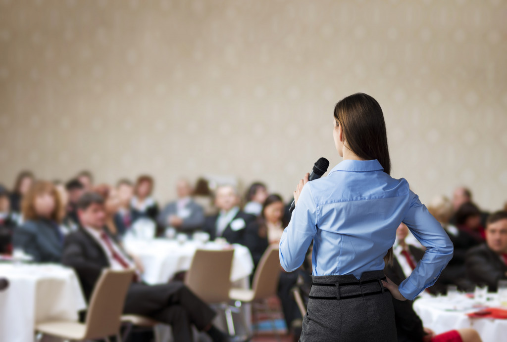 woman talking in front of people