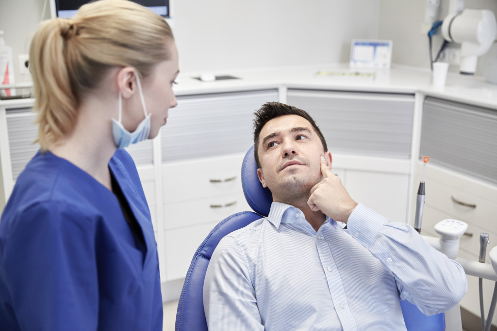 businessman dental patient pointing to his teeth