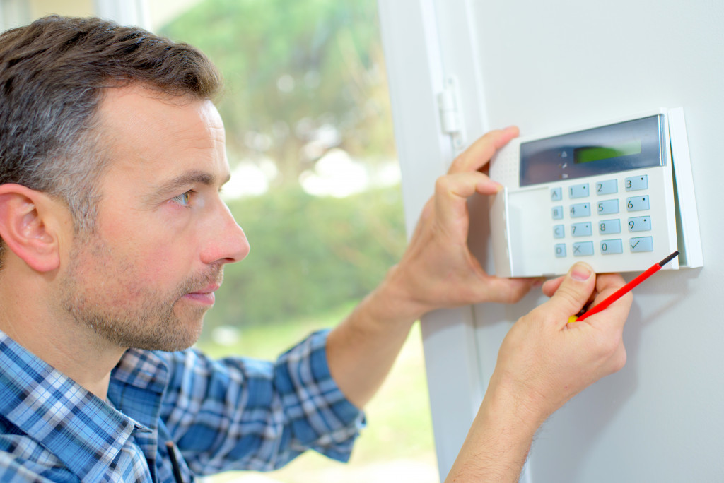 a man installing a security alarm