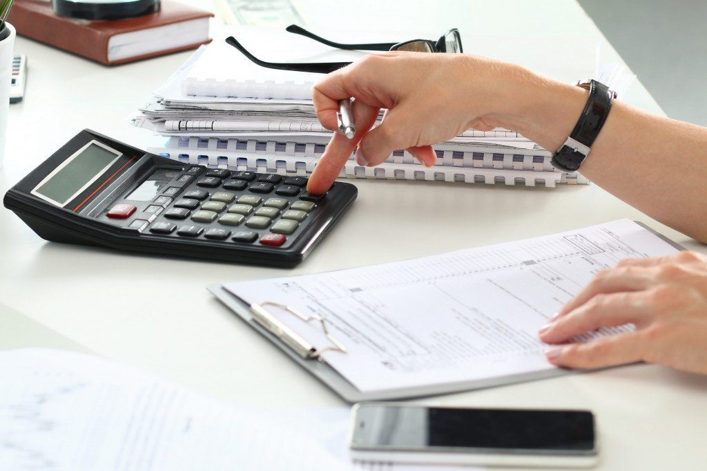 woman using calculator to budget for the party