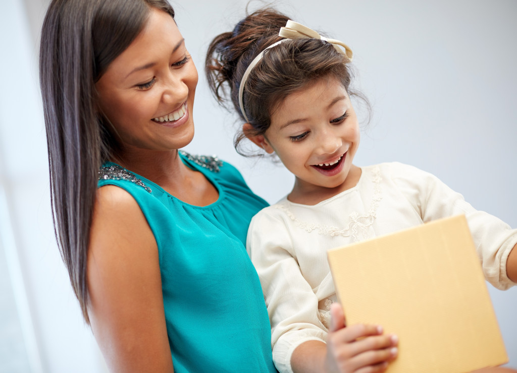 Single mother giving her daughter a gift.