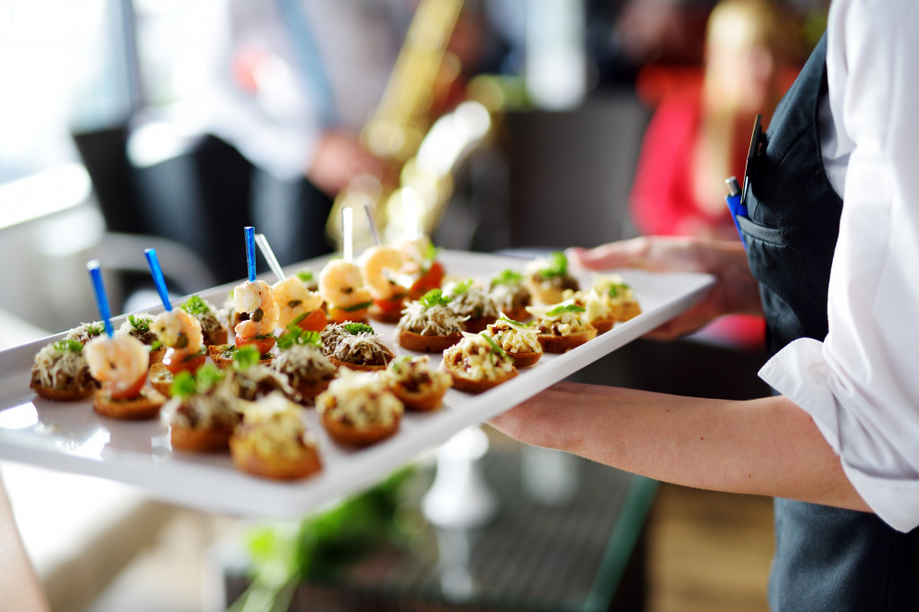 waitress carrying tray of dish for party food