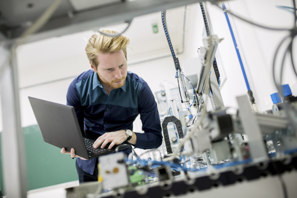 A computer engineer maintaining equipment in a factory