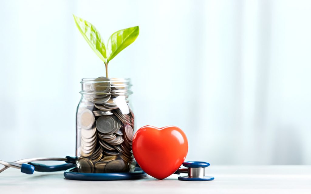 coin-filled glass jar with a plant sprouting, a heart figure, and a stethoscope on a table